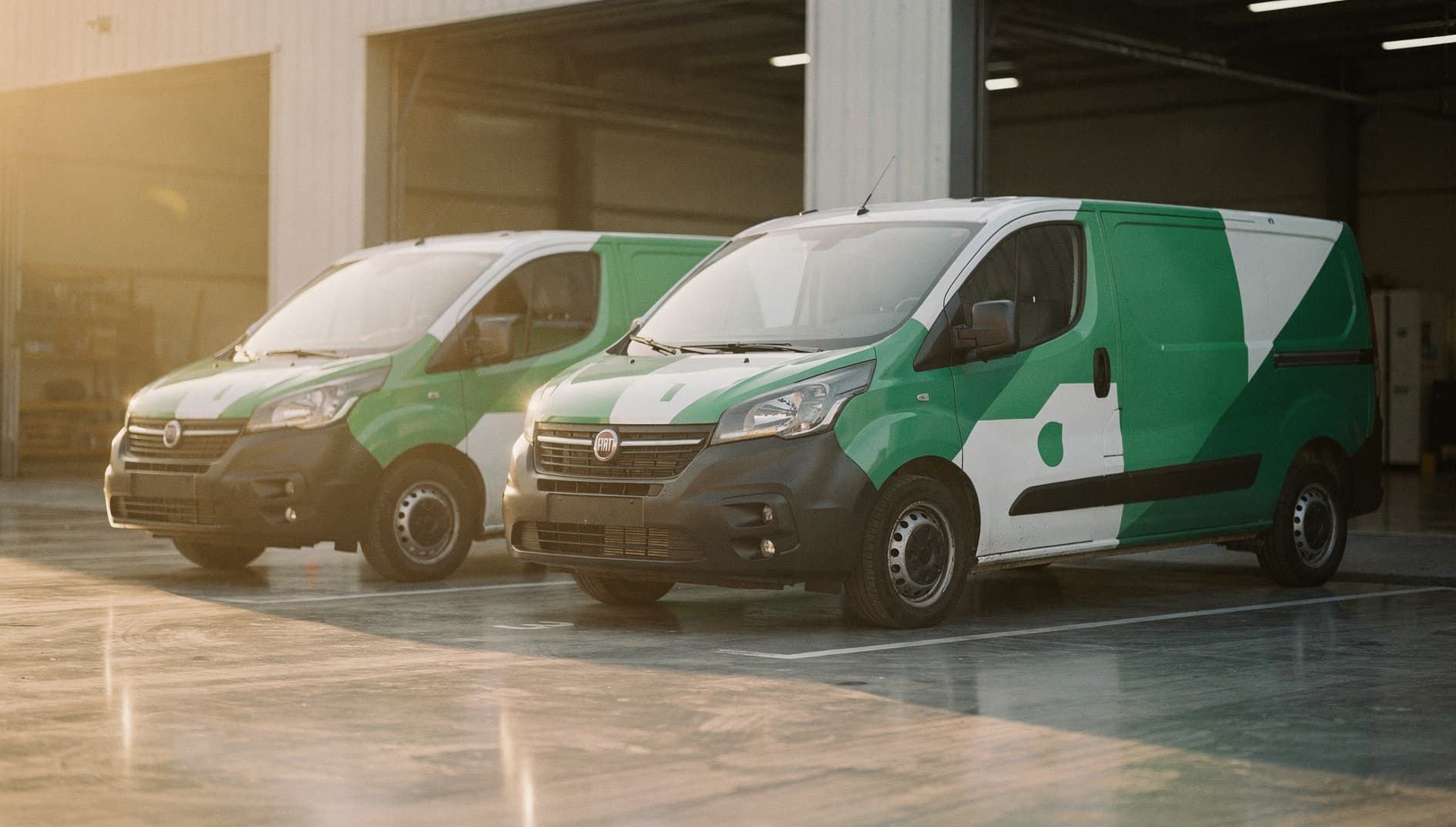 Delivery vans lined up in a warehouse loading bay at dawn