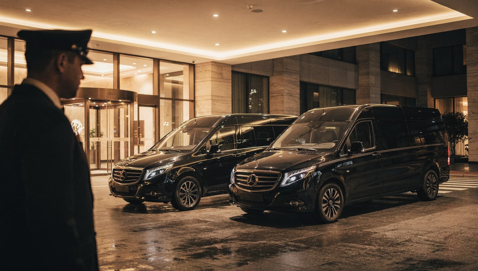 Executive sedan and Sprinter van at a luxury hotel porte-cochere